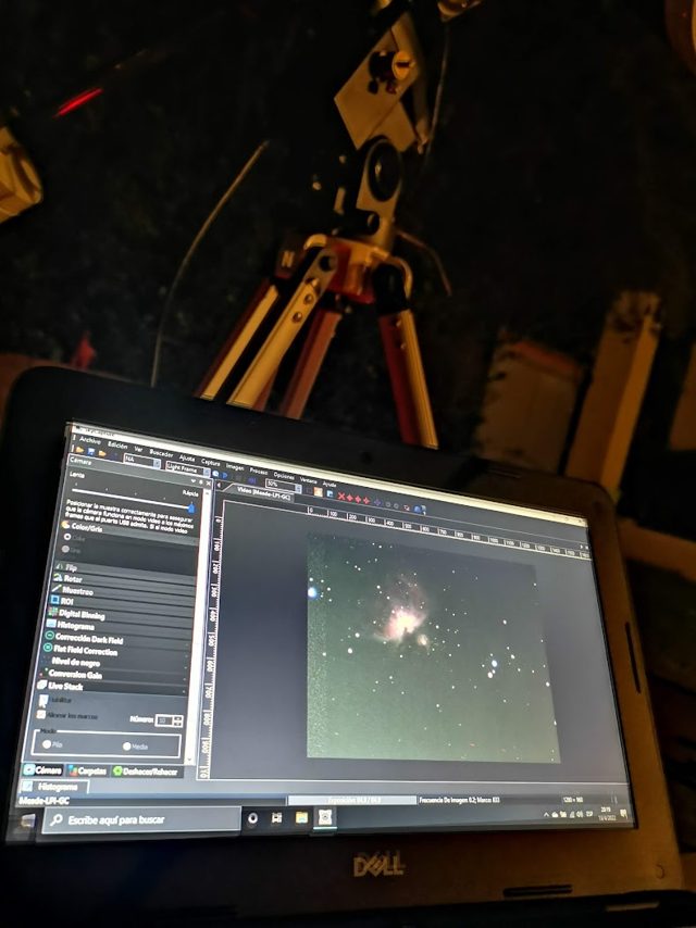 Notebook procesando una astrofotografía junto al telescopio
