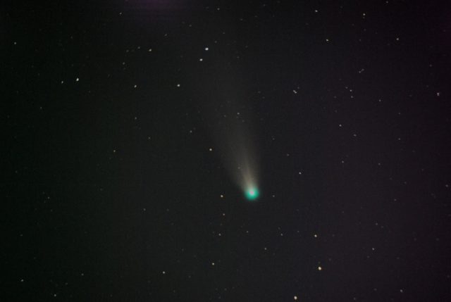 Un cometa con su cola sobre el fondo estelar